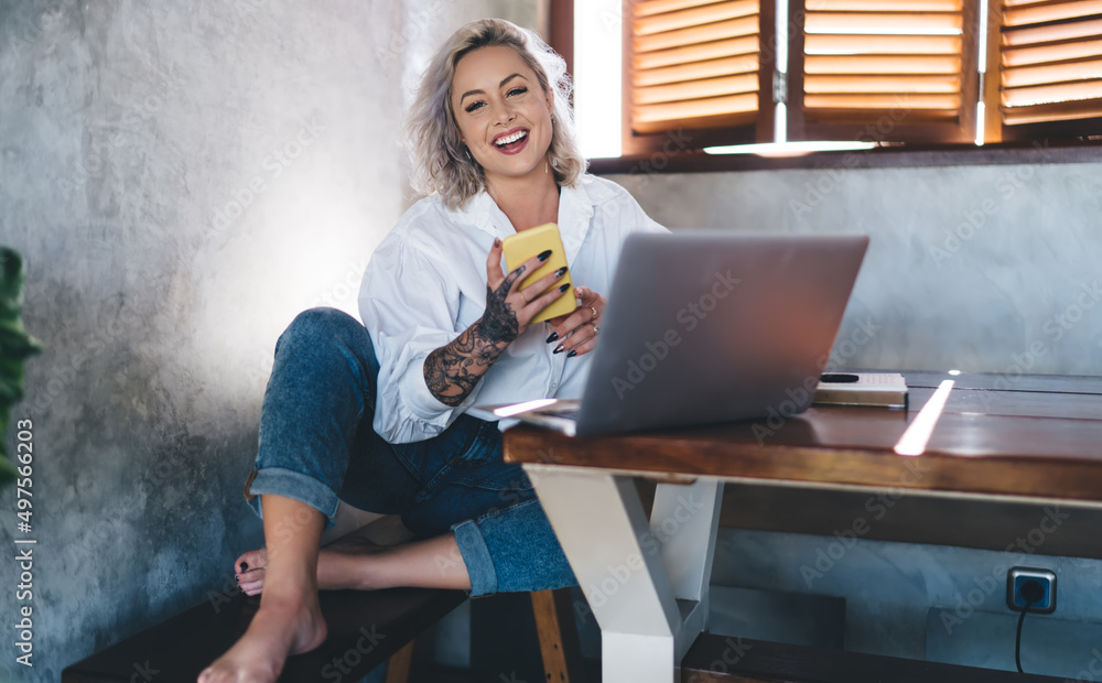 Aufkleber portrait of happy female freelancer with mobile phone and netbook computer smiling at camera while d