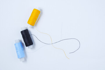 Three spools  multicolored sewing thread. White background.