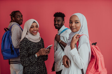 A group of African Muslim students with backpacks posing on a pink background. the concept of school education.