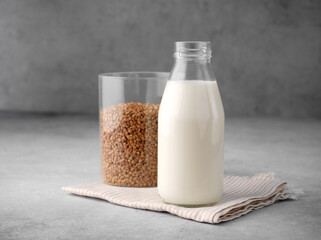Buckwheat groats, buckwheat flour and vegan buckwheat milk on a gray background, gluten-free...