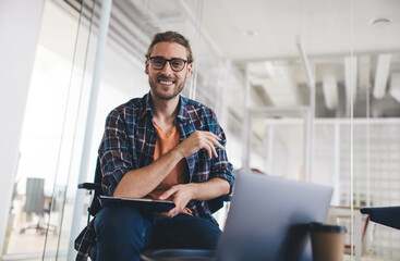Portrait of happy Caucaisan male copywriter with paperwork for planning smiling at camera in...