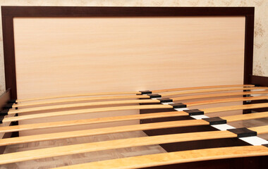 Frame of a simple lacquered bed made of wood with slats