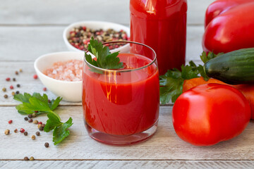 Juice from various vegetables and herbs on a wooden table. Healthy food rich in vitamins, microelements, antioxidants.