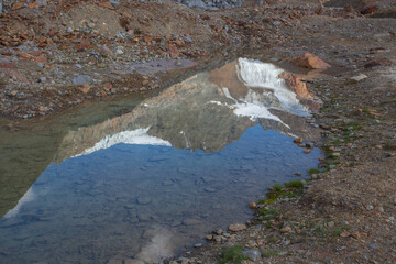 Mountains and glaciers reflected on a crystal clear pond. Vallelunga, Alto Adige, Italy