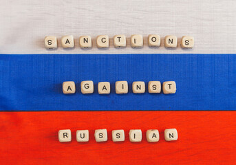 The words sanctions against Russia are written from wooden cube letters.