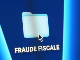 Fraude fiscale - photo macro d'un dossier sur un écran d'ordinateur