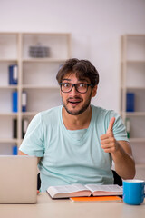 Young male student preparing for exams in the classroom