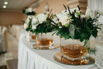 Table decoration for a special occasion - white plates and green plants. Eco/nature friendly decoration. 