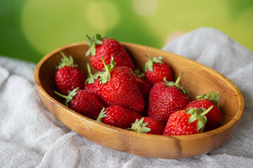 Juicy, tasty, ripe strawberries on a wooden plate, top view. Place for an inscription.