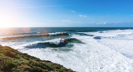 shot of giant wave breaking at the beach coastline of portugal