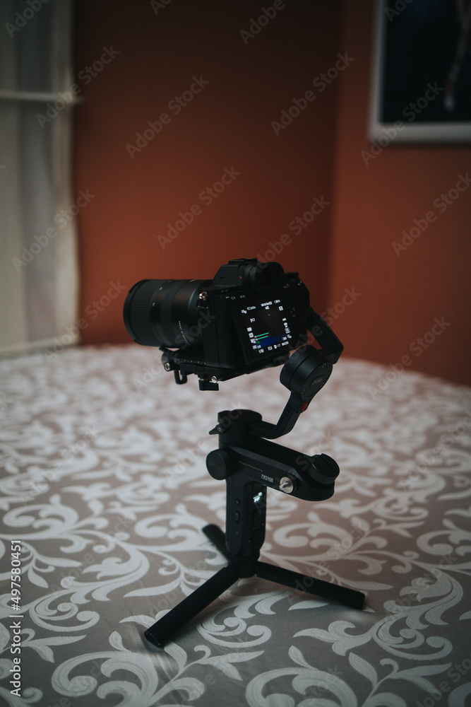 Poster vertical shot of a digital camera with a flip screen on a tripod