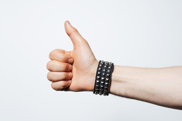 Close-up of male hand showing thumb up on white background.