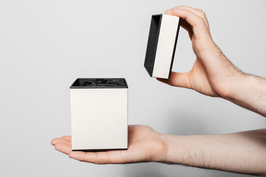 Close-up Of Male Hand Opens A Small Box On White Background.