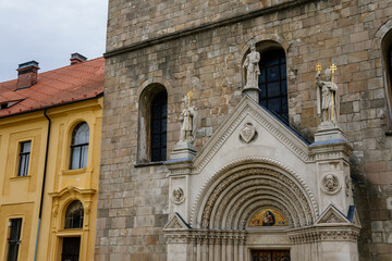 Tepla, Czech Republic, 7 August 2021: Premonstratensian Abbey and monastery, Romanesque church of the Annunciation with towers, gothic arched portal with stone carved statues of saints at summer day