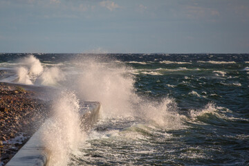 Piękne morze Bałtyckie, duże fale rozbijające się o brzeg skał, falochrony i mola. Spacer...