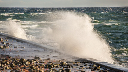 Piękne morze Bałtyckie, duże fale rozbijające się o brzeg skał, falochrony i mola. Spacer...