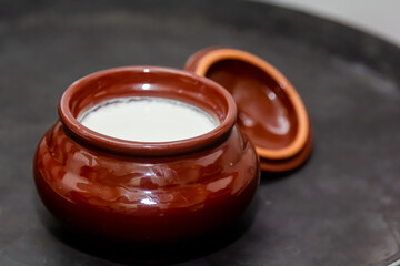 Milk or sour cream is poured into a ceramic pot