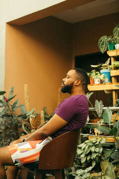 Relaxing portrait of a black gardener sitting in his nursery