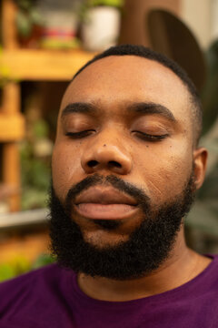 Portrait of a black gardener sitting in his plant in nursery relaxing in nature