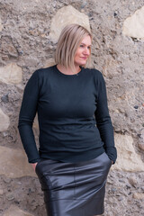 A woman in a leather skirt and a sweater in an abandoned house