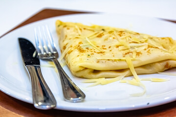 Russian pancakes with stuffing and sprinkled with grated cheese