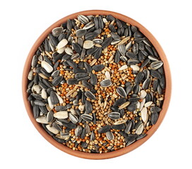 Mixed seeds millet, sunflower and oats pile for exotic birds in clay pot isolated on white, top view