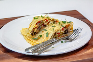 Russian pancakes with stuffing and sprinkled with grated cheese