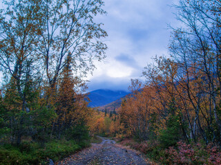 Dirt gravel road with mountains in the background. Autumn mountains of Khibiny