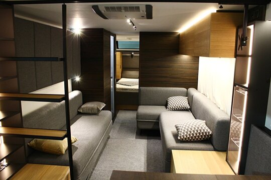 Comfortable sofas, cabinets and beds in rear part of large modern campervan Adria Astella, displayed on Caravan Expo in Nitra, Slovakia. 