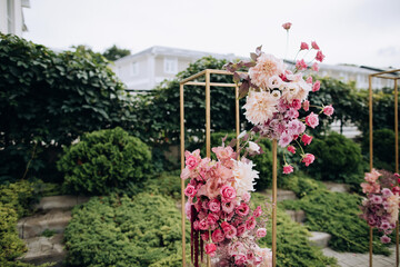 Wedding arch made of fresh pink flowers. Floristics at a wedding ceremony