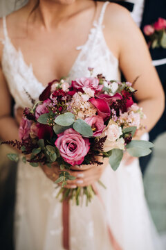 The bride holds a beautiful bouquet of pink roses