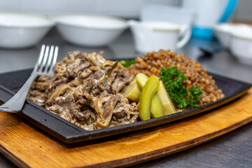 Beef Stroganoff - a traditional Russian dish with buckwheat porridge is on a plate