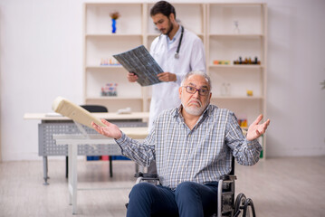 Old injured man visiting young male doctor radiologist