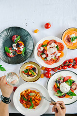 Variety of dishes on the table. Various snacks and antipasti on the table. Tomato menu in the restaurant. Top view