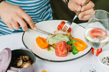 Pork fillet on the bone, with baked tomatoes and confit garlic. Food tasting in a restaurant