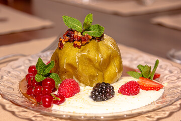 Baked apple with honey, nuts, berries and white sauce