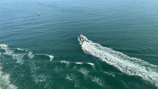 A pilot boat escorting a cruise ship out of Port Canaveral, FL.