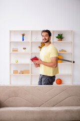 Young man reading book at home during pandemic