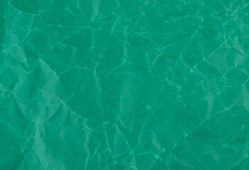 Wrinkled sheet of dark green paper. Textured backdrop