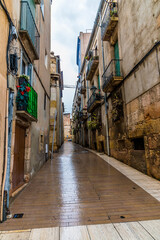 A view up a narrow street in the centre of the city of Tarragona on a spring day