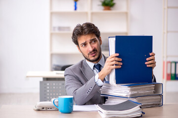 Young male employee and too much work in the office