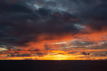 Amazing sunset with colorful clouds and dark ocean water, nature background