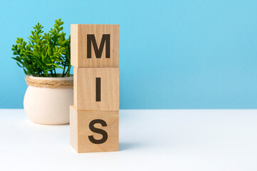 mis - word from wooden blocks with letters, blue background. copy space available
