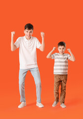 Portrait of happy brothers on color background