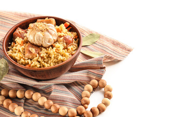 Bowl with tasty Asian pilaf and tasbih on white background