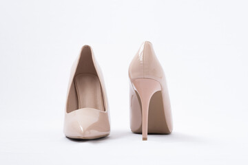 Elegant beige women's shoes with high heels. White background. Polished leather. back view