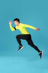 Sporty male runner on color background