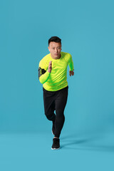 Sporty male runner on color background