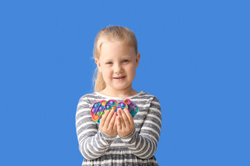 Portrait of little girl with different pop it fidget toys on color background - obrazy, fototapety, plakaty