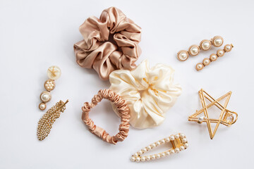 Collection of trendy silk elastic band scrunchies and pearl hair clips on white background. Diy...